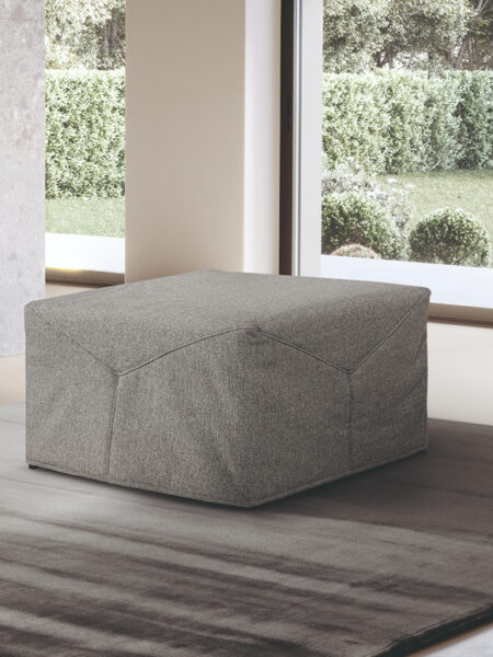 Pouf Celine versione chiusa e tessuto grigio in ambiente neutro con tappeto