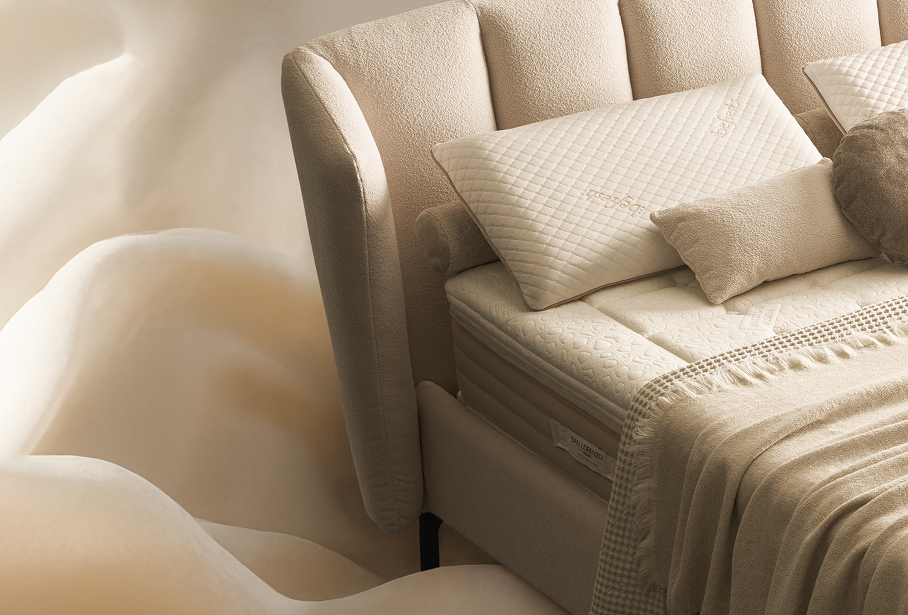 Dettaglio di un letto con materasso, guanciali e cuscini arredo disposto su un telo